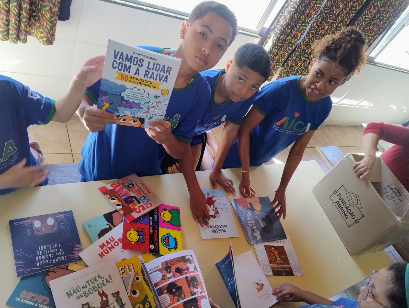 Crianças recebendo acervo literário 