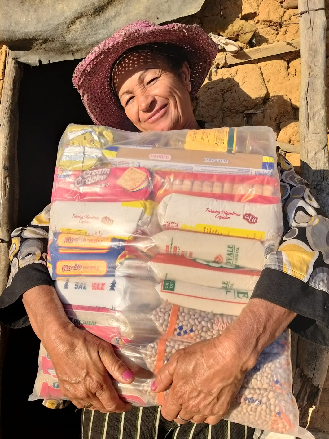 Dona Chica ao receber a cesta básica.