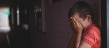Foto de criança escondendo o rosto com as mãos