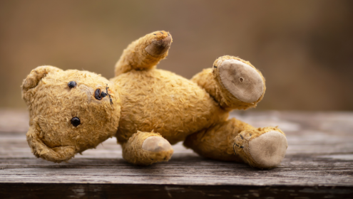 Foto de um urso de pelúcia caído no chão