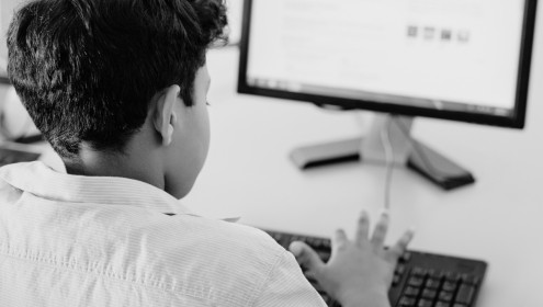 Foto em preto e branco de criança usando o computador