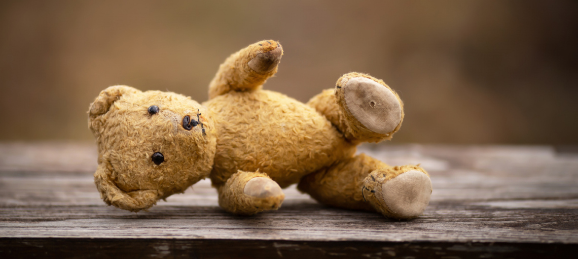 Foto de um urso de pelúcia caído no chão