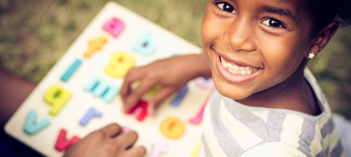 Criança sorrindo com caderno de lição